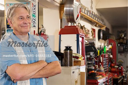 Homme senior souriant en atelier automobile