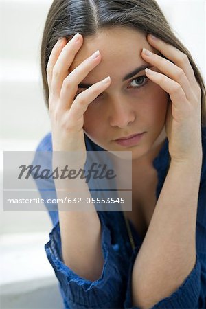 Young woman holding head, portrait