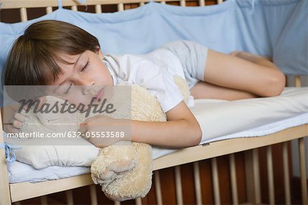 Junge in Bettchen schlafen