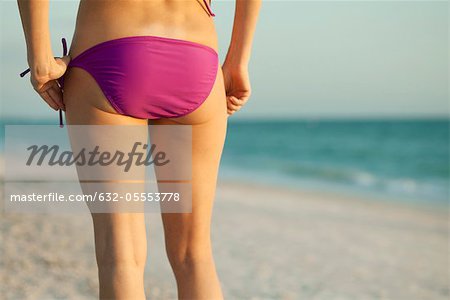 Frau im Bikini am Strand, Rückansicht