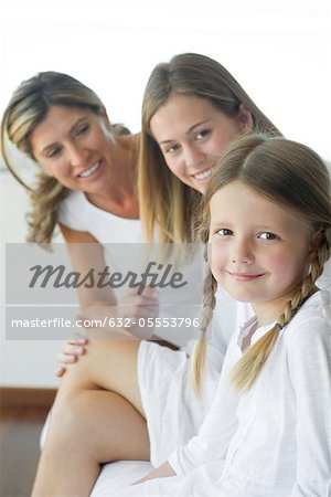 Girl sitting with mother and grandmother, portrait