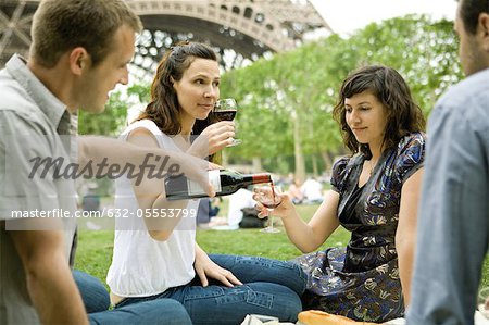 Amis dégustant vin au pique-nique près de la tour Eiffel, Paris, France