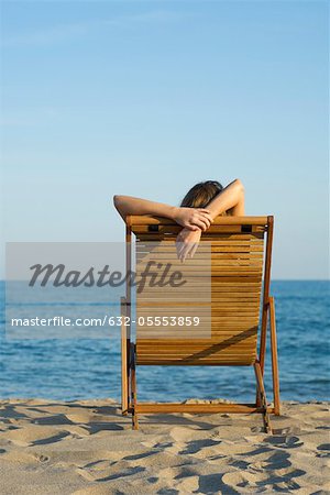 Woman relaxing in lounge chair on beach