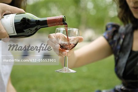 Pouring glass of red wine outdoors