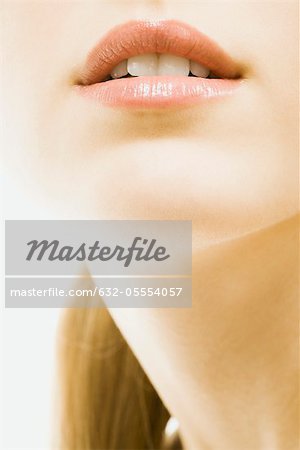 Junge Frau trägt Lipgloss, close-up Gesicht, zugeschnitten