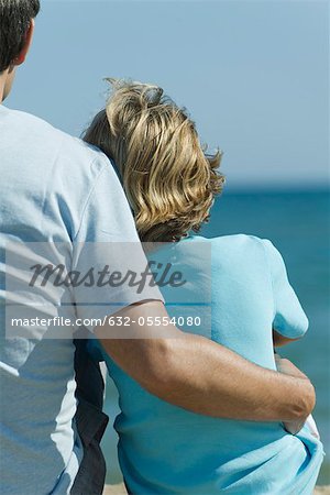 Père et fils s'asseoir ensemble à la plage, vue arrière