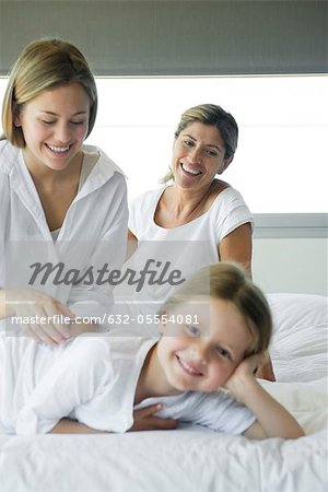 Fille reposante sur le lit avec sa mère et sa grand-mère