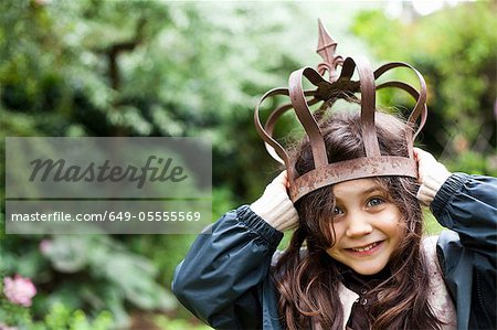 Girl playing with metal crown outdoors