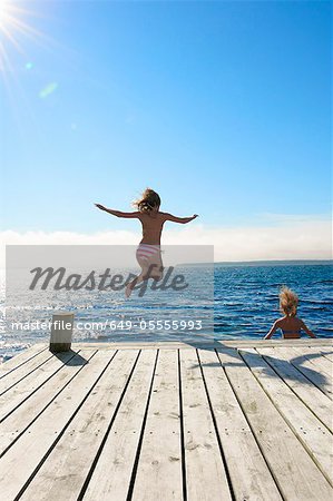 Weibliche Teenager einen Sprung in den See Weibliche Teenager einen Sprung in den See