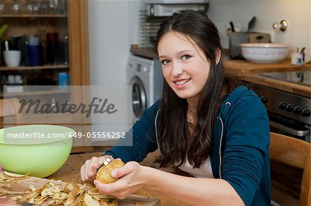 Mädchen schälen Kartoffeln in Küche