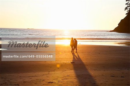 Couple walking on beach on sunset