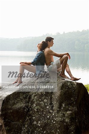 Young couple leaning on each other on rock