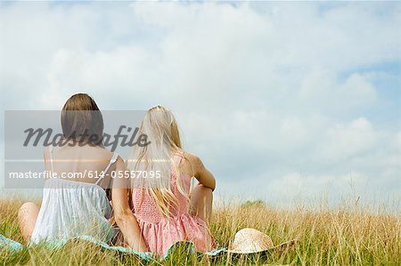 Young lesbian couple sitting together in countryside