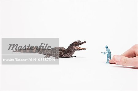 Small reptile attacking toy soldier