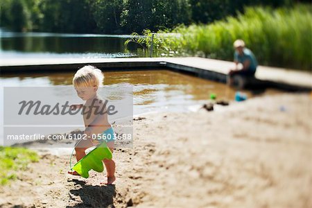 Girl running beside lake in sun