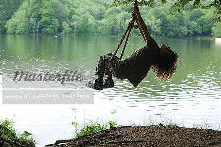 Boy on swing by lake