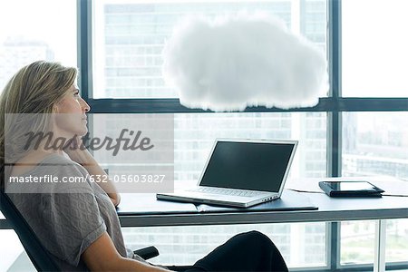 Woman sitting at desk with laptop computer. cloud above laptop computer