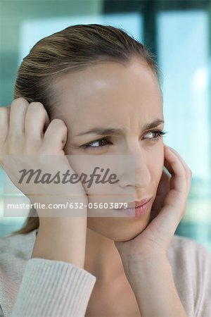 Woman with head in hands, looking frustrated