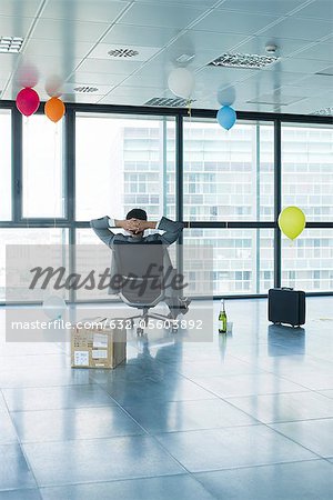 Geschäftsmann, sitzen im neuen Büro mit Luftballons und box