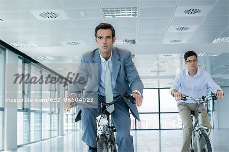 Hommes d'affaires de bicyclettes à l'intérieur d'équitation