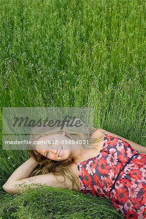 Jeune femme reposante dans des herbes hautes, portrait