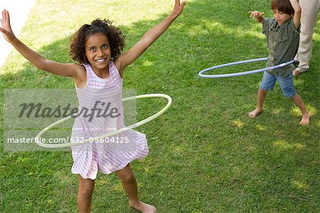 Children playing with plastic hoop outdoors