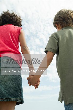 Children holding hands, rear view