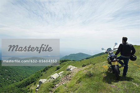 Mann mit dem Motorrad auf Berg, Rückansicht