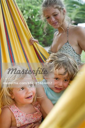 Mother watching children in hammock