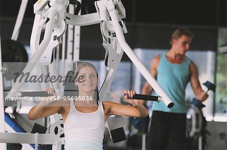 Jeune femme prenant l'entraînement physique avec un appareil d'exercice