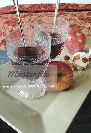 Two ornate glasses with apples and cookies