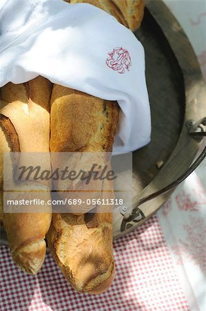 Three baguettes in wooden bowl