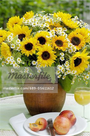 Bouquet de fleurs et fruits sur table de jardin