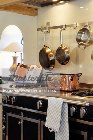 Pans and cookbook at stove in kitchen Pans and cookbook at stove in kitchen