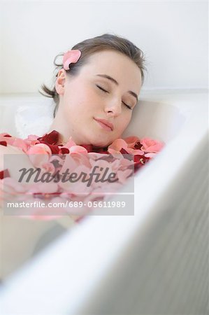 Junge Frau mit Rosenblüten Bad genießen