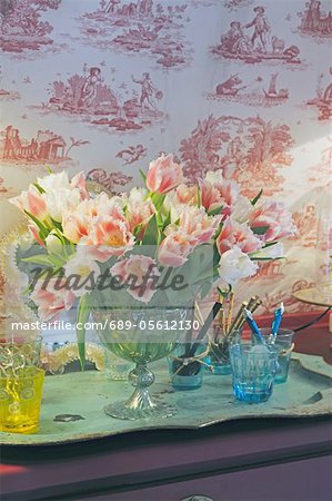 Bunch of flowers and glasses on dresser