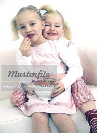 Two girls with bowl of strawberries