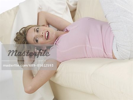 Happy woman lying on couch