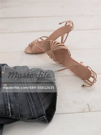 Jeans and womens shoes on wooden floor Jeans and womens shoes on wooden floor