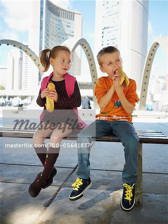 Garçon et fille manger des hot-dogs, Nathan Philips Square, Toronto, Ontario, Canada