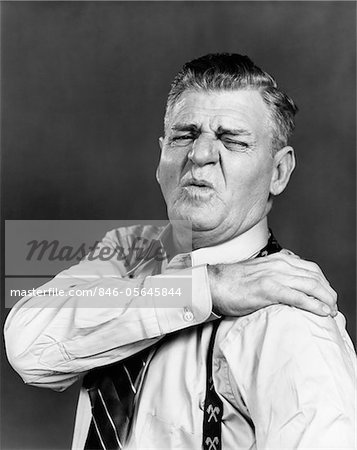 1940s ELDERLY MAN GRIMACING AND HOLDING SHOULDER IN PAIN
