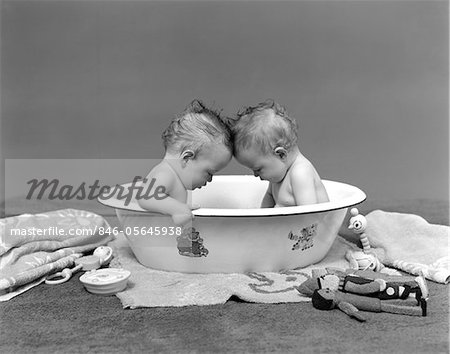 Annees 1930 Deux Bebes Jumeaux Dans Le Baquet De Bain Regardant Vers Le Bas Photographie De Stock Masterfile Rights Managed Artiste Classicstock Code 846