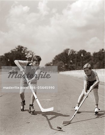 1930s - 1940s 2 BOYS WITH STICKS AND PUCK WEARING ROLLER SKATES PLAYING STREET HOCKEY