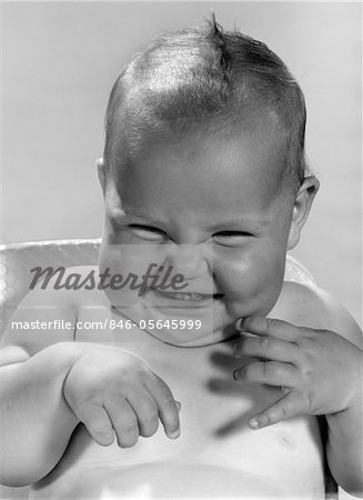 ANNÉES 1960 PORTRAIT DE BÉBÉ SOURIANT SOURIRE INTÉRIEUR FAISANT UNE DRÔLE DE TÊTE