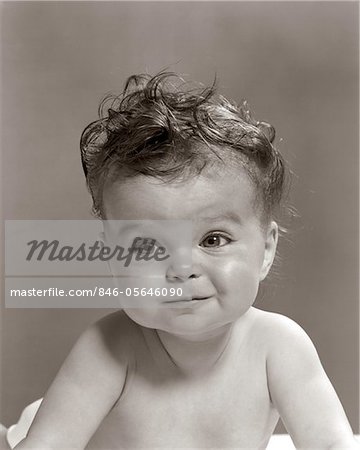 1950s PORTRAIT BABY WITH MESSY CURLY HAIR & STRAIGHT FACE