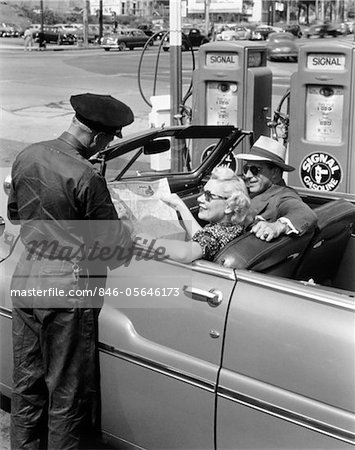 1950s COUPLE WITH MAP IN CAR CONVERTIBLE ASKING DIRECTIONS FROM GAS STATION ATTENDANT