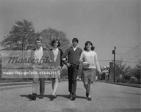 1960s TWO YOUNG TEEN COUPLES WALKING TOGETHER ARM IN ARM