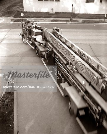 1960s ELEVATED VIEW HOOK AND LADDER FIRE TRUCK LEAVING THE FIRE STATION