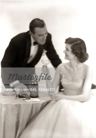 1950s FORMAL DRESS COUPLE MAN IN TUXEDO WOMAN WEARING GOWN HOLDING CHAMPAGNE GLASS