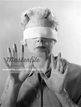 1960s ELDERLY WOMAN WEARING BLINDFOLD HOLDING UP HER HANDS
